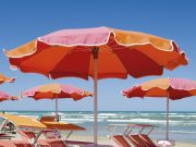 Turismo, i conti non tornano spiaggia di rimini con brandine e ombrelloni